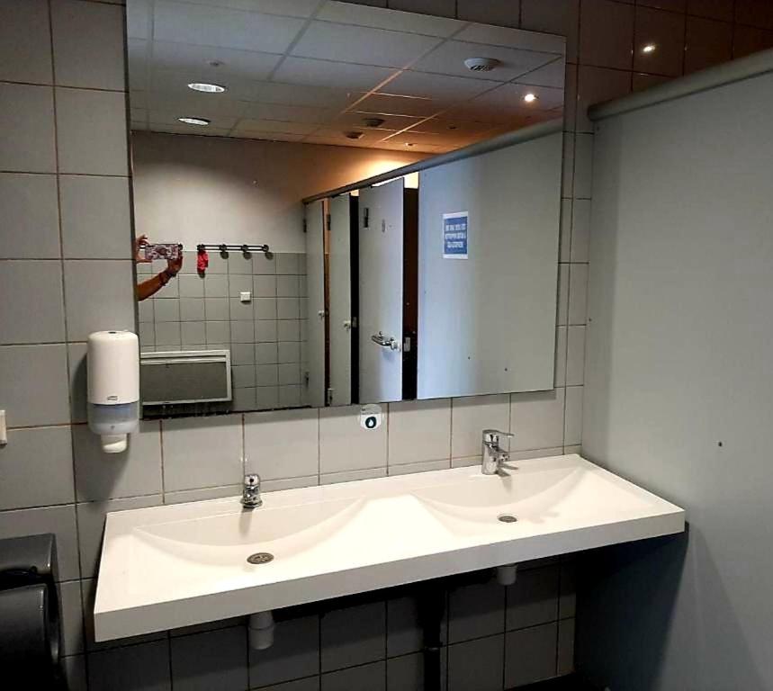 a bathroom with a sink and a large mirror at Bateau le Zimon - logement insolite in Rouen