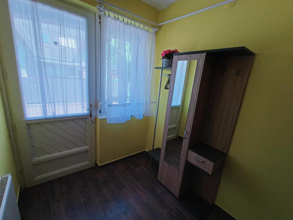 a room with a door and a window and a mirror at AMRI Apartman in Balatonföldvár