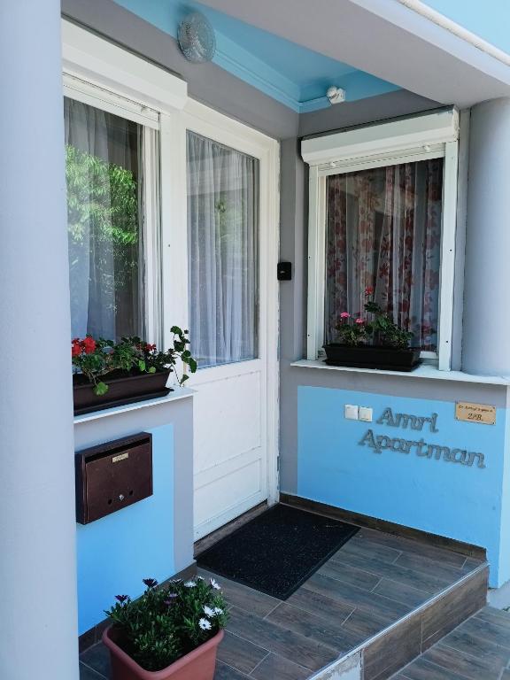 a front door of a house with two windows at AMRI Apartman in Balatonföldvár