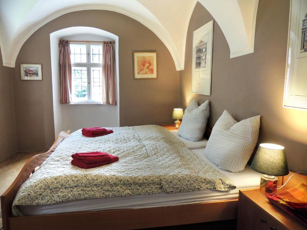 1 dormitorio con 1 cama grande y 2 almohadas rojas. en Wohnung im Schlösschen, en Lichtenfels