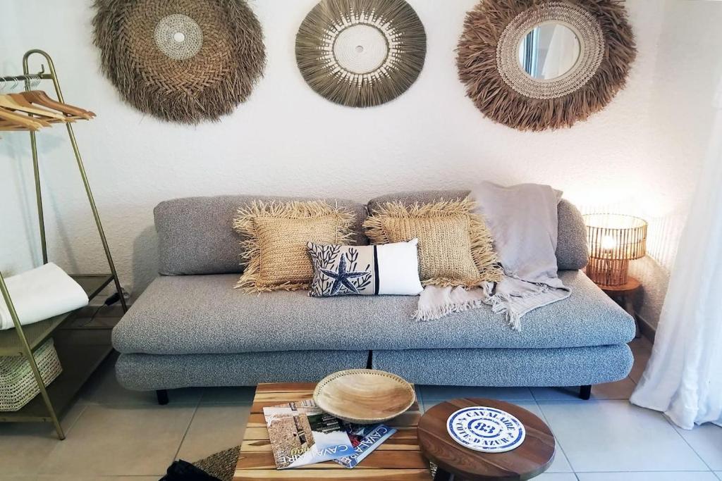 - un salon avec un canapé, des oreillers et des miroirs dans l'établissement Joli appartement tout équipé, plage et centre 200m, à Cavalaire-sur-Mer