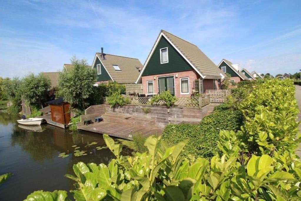 una casa con un muelle junto a un cuerpo de agua en KG- Vakantiewoning 20, en Opperdoes