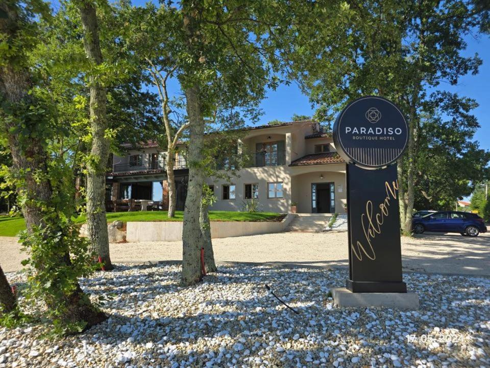 a sign in front of a house with a building at Boutique Hotel Paradiso in Poreč