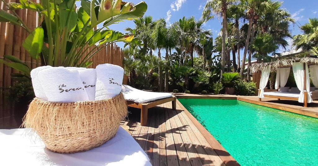 um resort com uma piscina, uma cadeira e uma planta em VILLA SERENITY 3 Luxury boutique villa em Sant Jordi