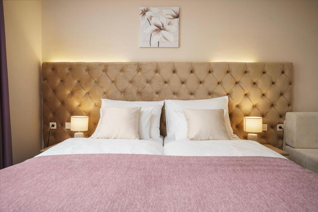 una camera da letto con un grande letto con due cuscini bianchi di Hotel Stella Maris a Vodice