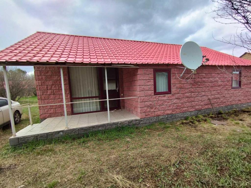 una pequeña casa de ladrillo rojo con satélite en Lavanda Beach House, en Sevan