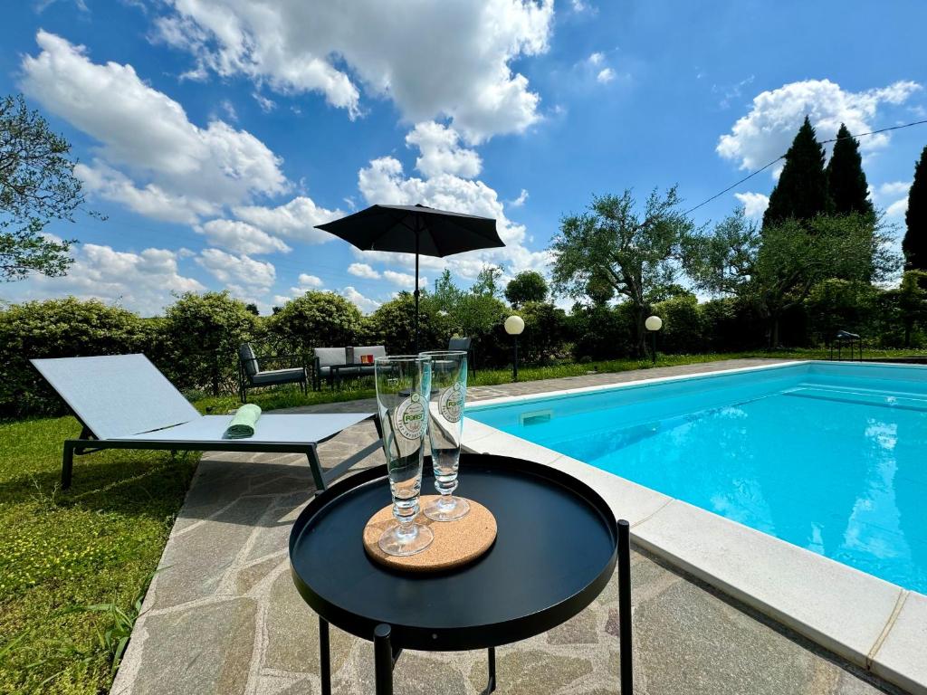 uma mesa com copos ao lado de uma piscina em Casa 18 em Monzambano