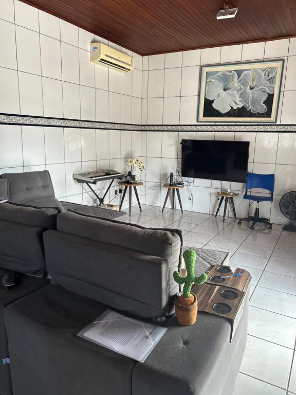 uma sala de estar com um sofá e uma televisão em Casa mobiliada - Rondônia Rural Show em Ji-Paraná