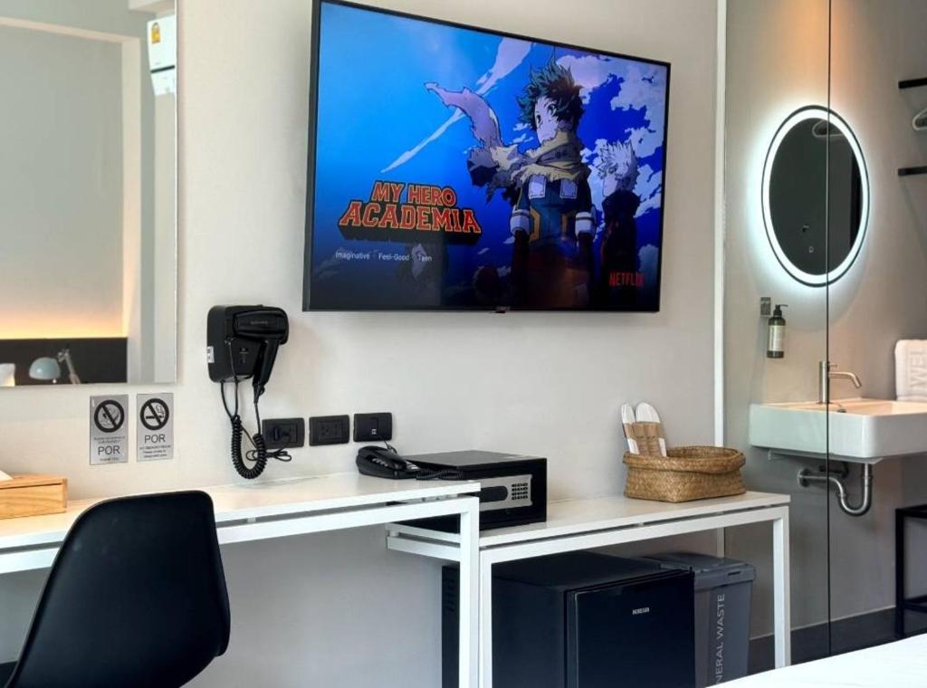 A compact in-room workstation sits beneath a television beside the vanity area.