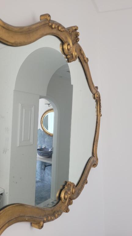 espejo grande con marco de madera en la pared en Casa Lucia Relaxing rooms en Anacapri