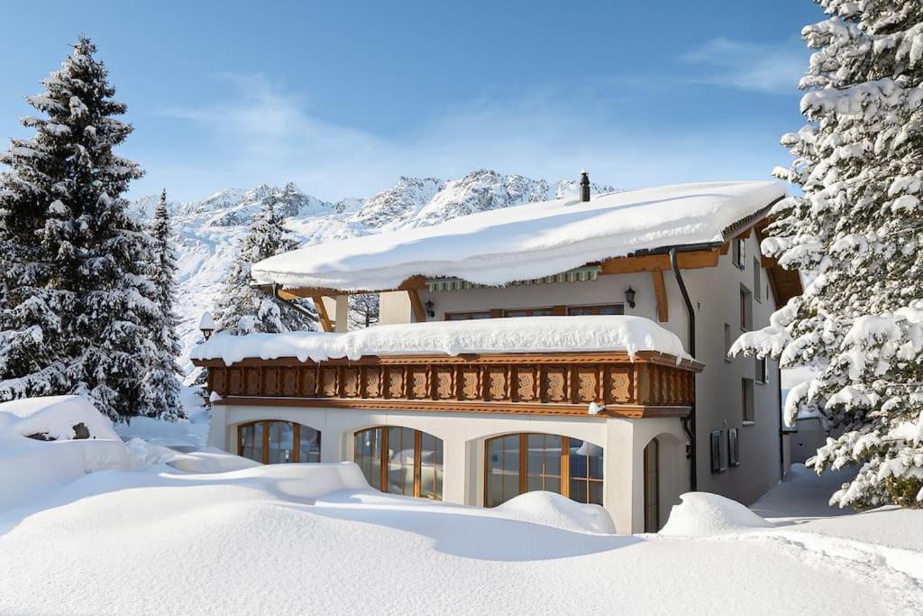 ein schneebedecktes Haus mit schneebedeckten Bäumen in der Unterkunft Chalet Gütsch Andermatt in Andermatt