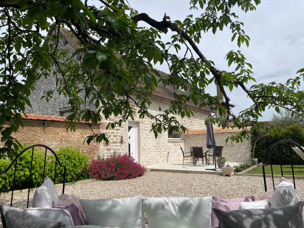 una casa de piedra con un patio frente a ella en L'histoire d'une hirondelle, en Bouafles