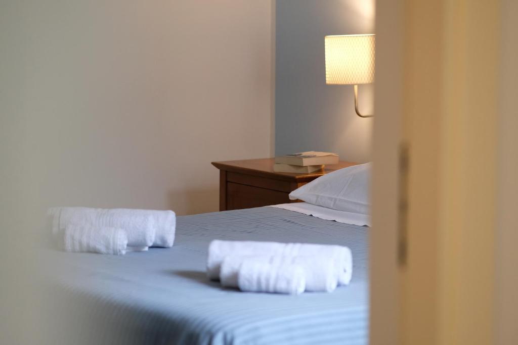 una camera da letto con 2 asciugamani bianchi su un letto di Gli Ulivi Apartment a Capaccio-Paestum