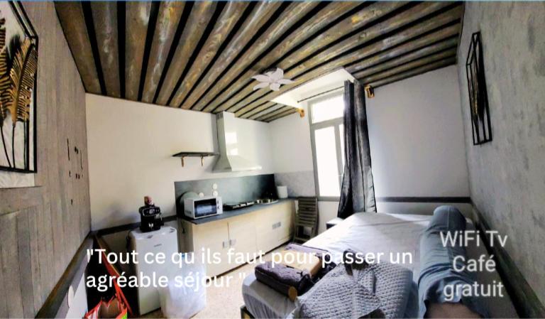 - une chambre avec un lit et un plafond en bois dans l'établissement Gite de la tour, proche Nîmes ,Avignon, à Montfrin