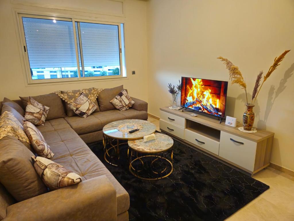 sala de estar con sofá y TV en Beachfront Gorgeous Flat in Tangier, en Tánger