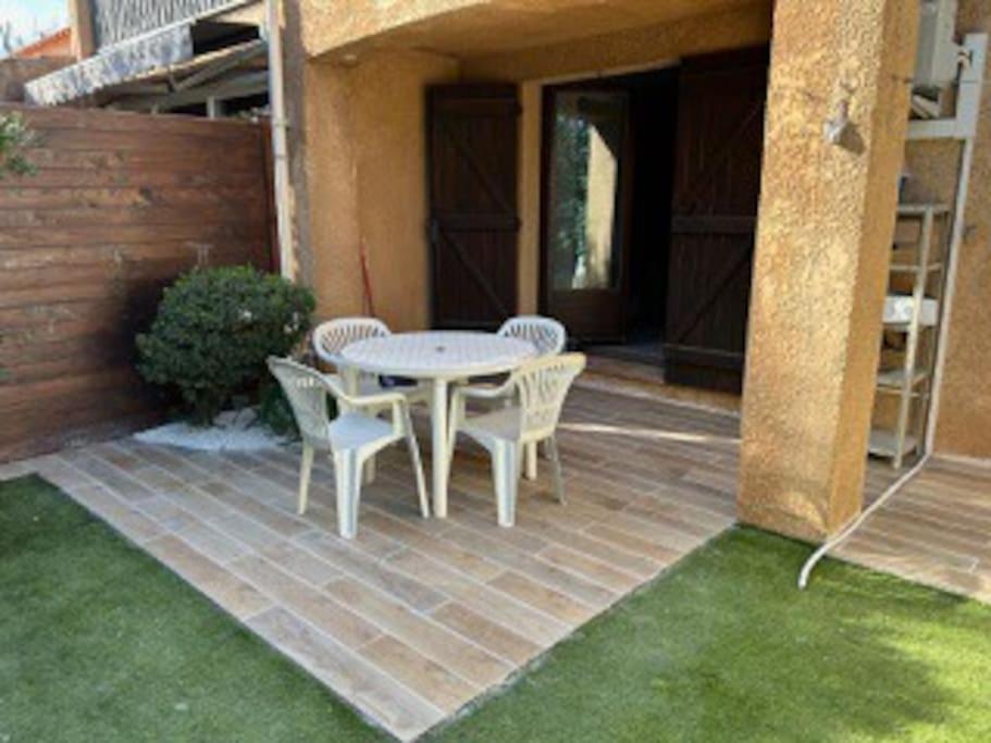 d'une terrasse en briques avec une table et des chaises. dans l'établissement Appartement proche plage, à La Londe-les-Maures