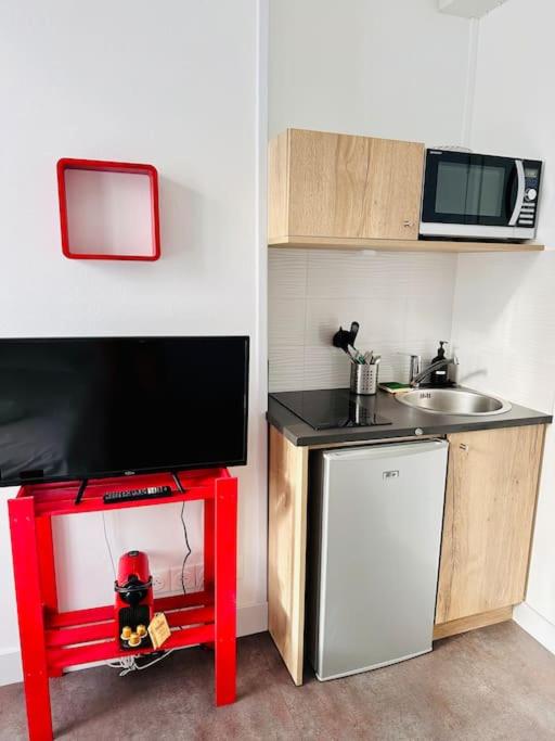 une petite cuisine avec un évier et un micro-ondes dans l'établissement Lakanal 2 - Studio Prébendes Tours, à Tours