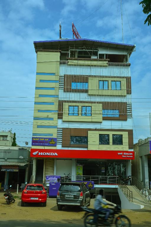 a building with cars parked in front of it at Royal Rock INN in Harihar
