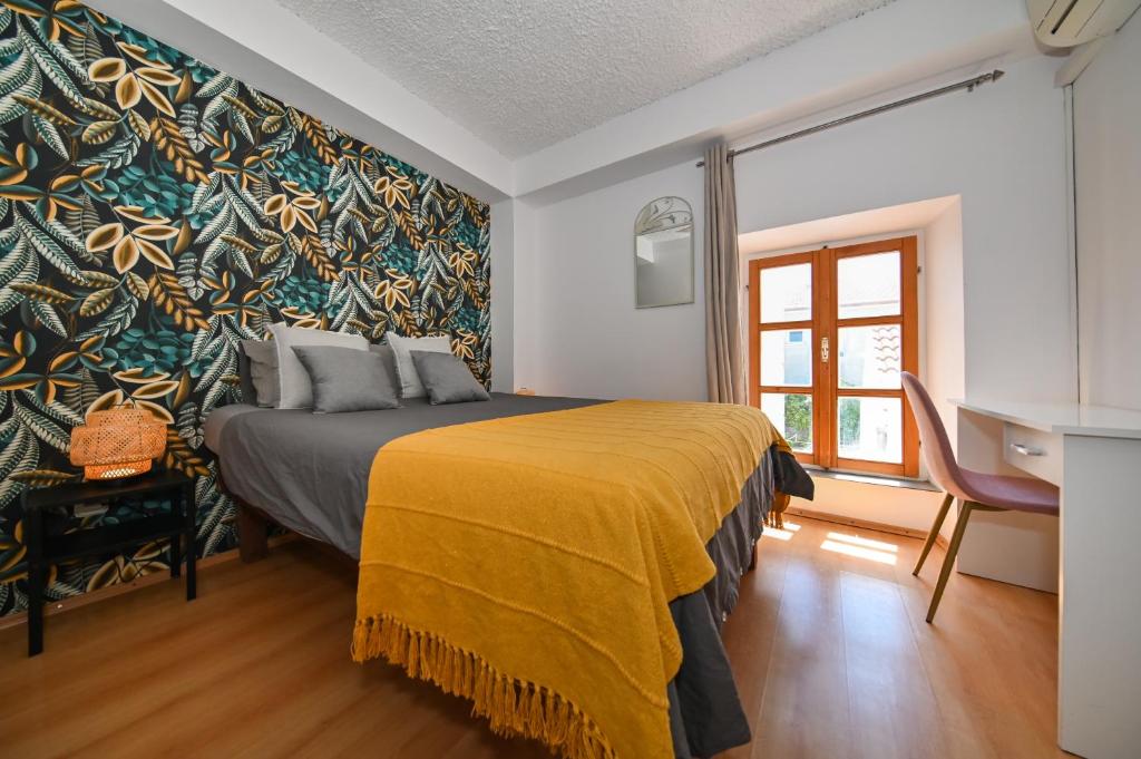 1 dormitorio con 1 cama con manta amarilla en The Lazy Monkey Hostel & Apartments en Zadar