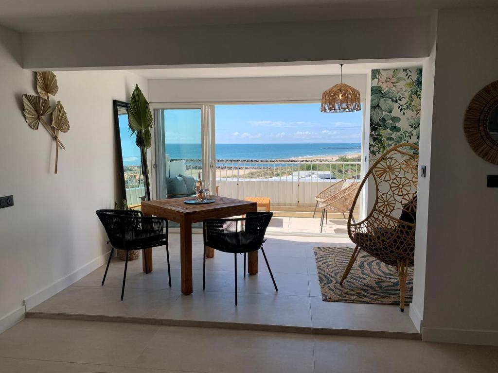une salle à manger avec une table et une vue sur l'océan dans l'établissement Favorite duplex Port nature, au Cap d'Agde