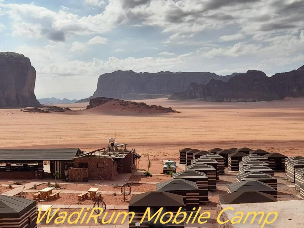 a group of tents in a desert with mountains at WadiRum Mobile Camp in Wadi Rum