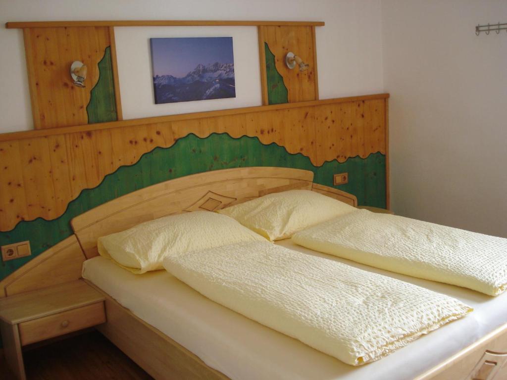 a bedroom with a wooden headboard and two beds at Appartement Ahornegger in Schladming