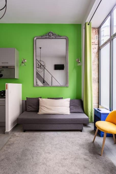Cette chambre verte comprend un lit et un miroir. dans l'établissement Casa Blanca, à Paris