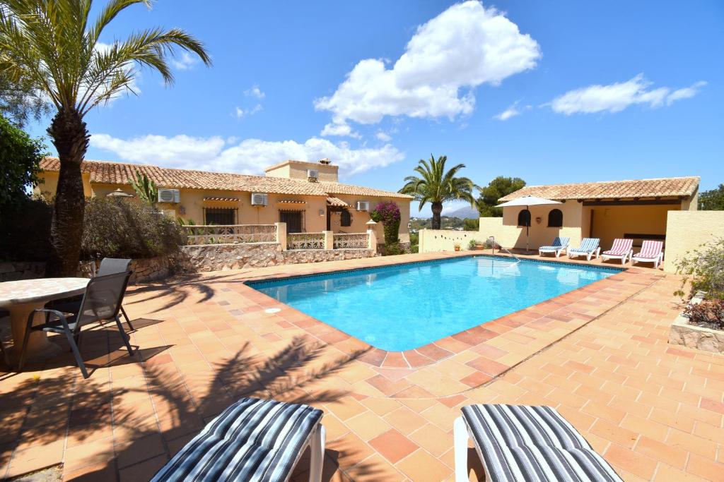 a pool with chairs and a table and a house at Casa Vista Montgo Javea - 5048-3 in Balcon del Mar