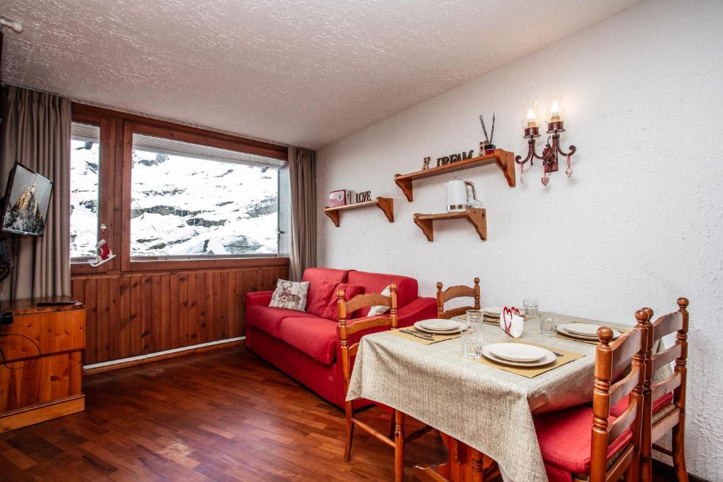 a living room with a red couch and a table at Marcolski home in Breuil-Cervinia