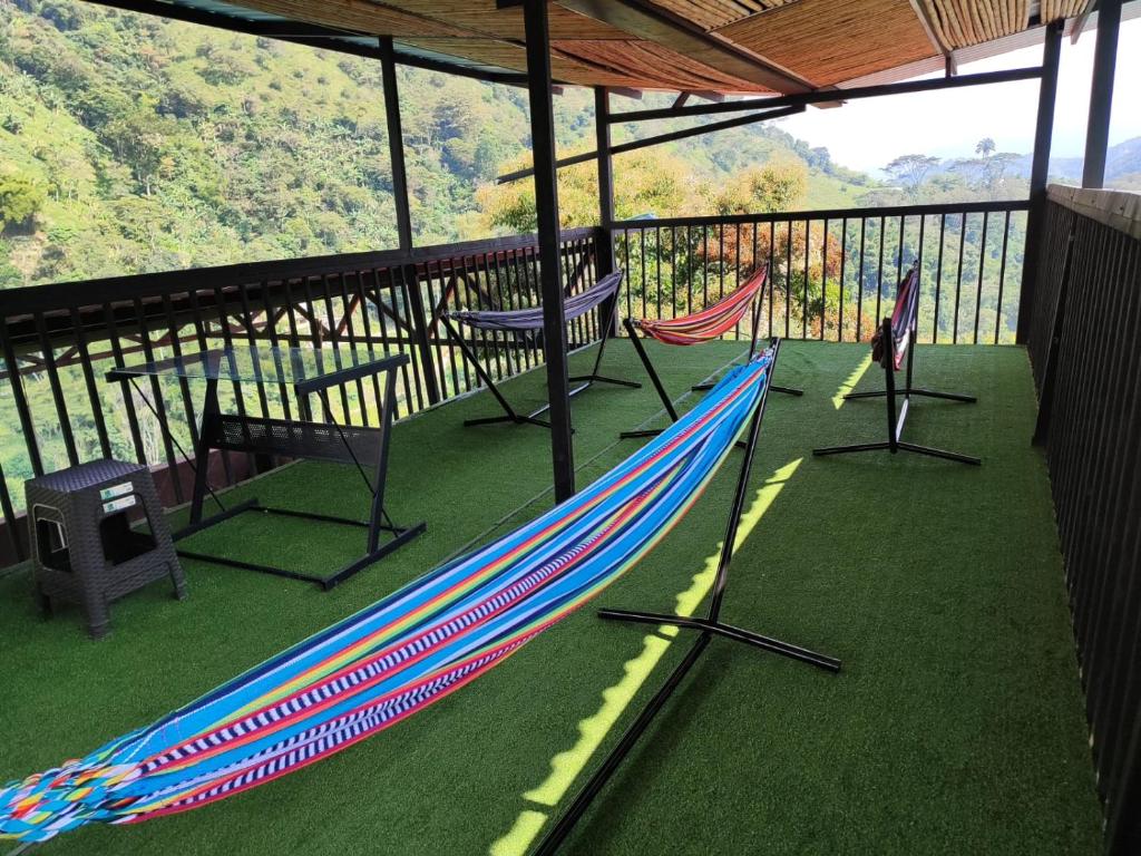 a deck with two hammocks and a table and chairs at SAN FELIPE CASA QUINTA in Ibagué