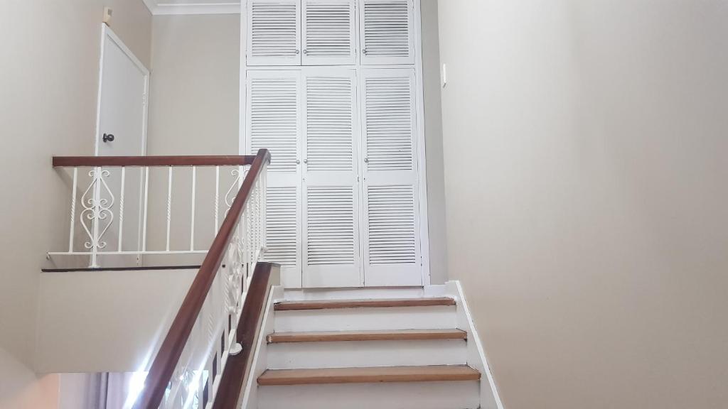 a staircase with a white door and a window at Multiplex with a view in Durban