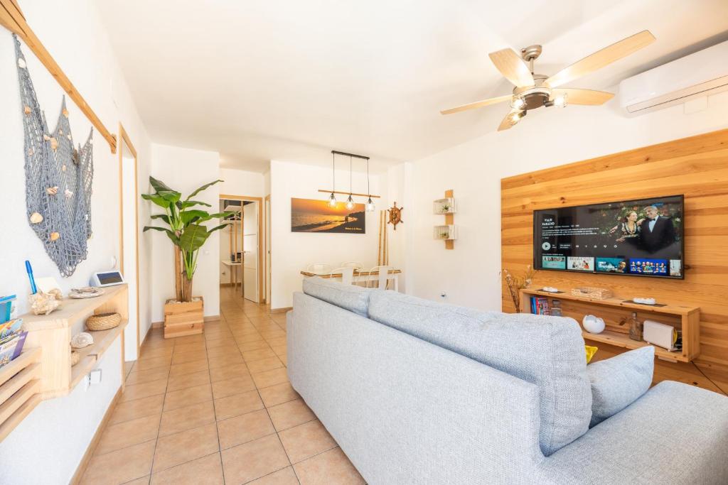 奇克拉納－德拉弗龍特拉的住宿－Apartamento Playa La Barrosa，客厅配有蓝色的沙发和电视