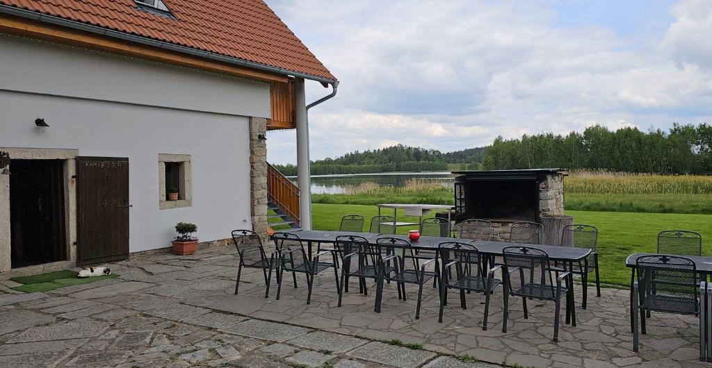 un patio con mesa, sillas y chimenea en Ubytování u Knotků, en Nová Bystřice