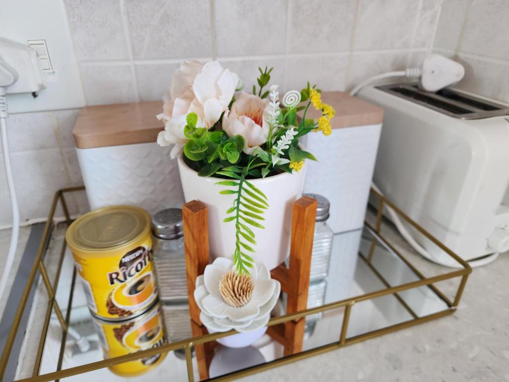 un vase blanc rempli de fleurs sur une étagère dans l'établissement Faerie Glen Heights-No Load Shedding, à Pretoria
