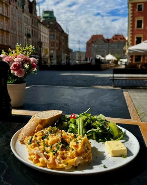 a plate of food with a salad and a piece of bread at Staycity Apartments Sukiennice 6 in Wrocław
