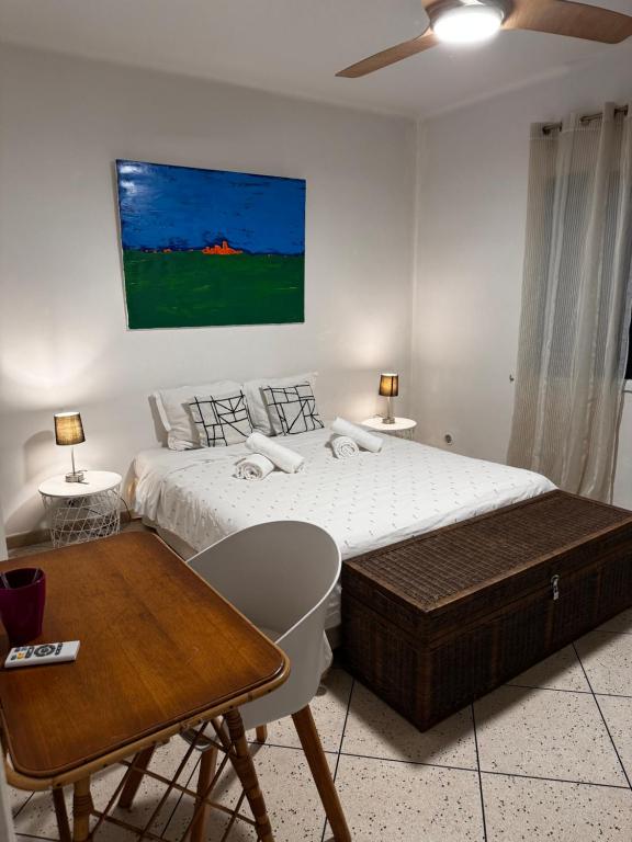 - une chambre blanche avec 2 lits et une table dans l'établissement Villa Butterfly - Jardin - Plage 400m, à Juan-les-Pins