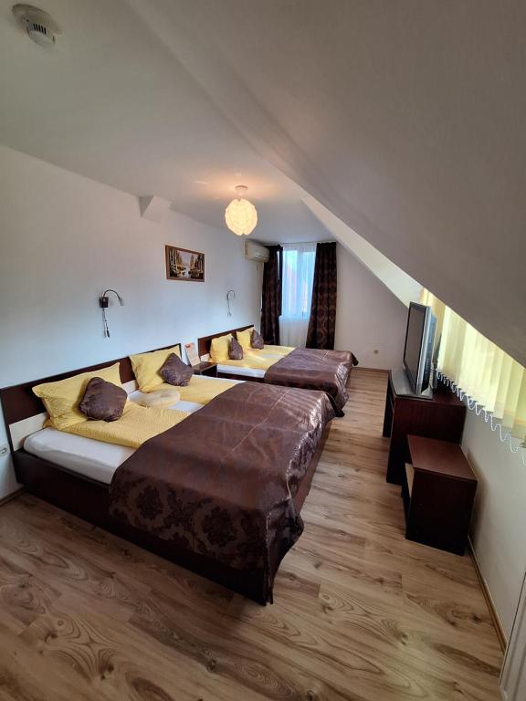 1 dormitorio con 2 camas y escalera en Neon2 - Vendégház en Orosháza