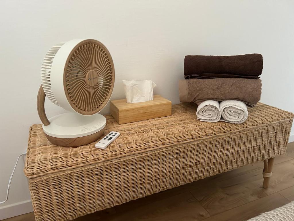 a fan sitting on top of a wicker table at Studio EASY CHECK-IN 8 mins Disneyland 35 mins Paris FREE Starbucks coffee parking wifi in Bussy-Saint-Georges