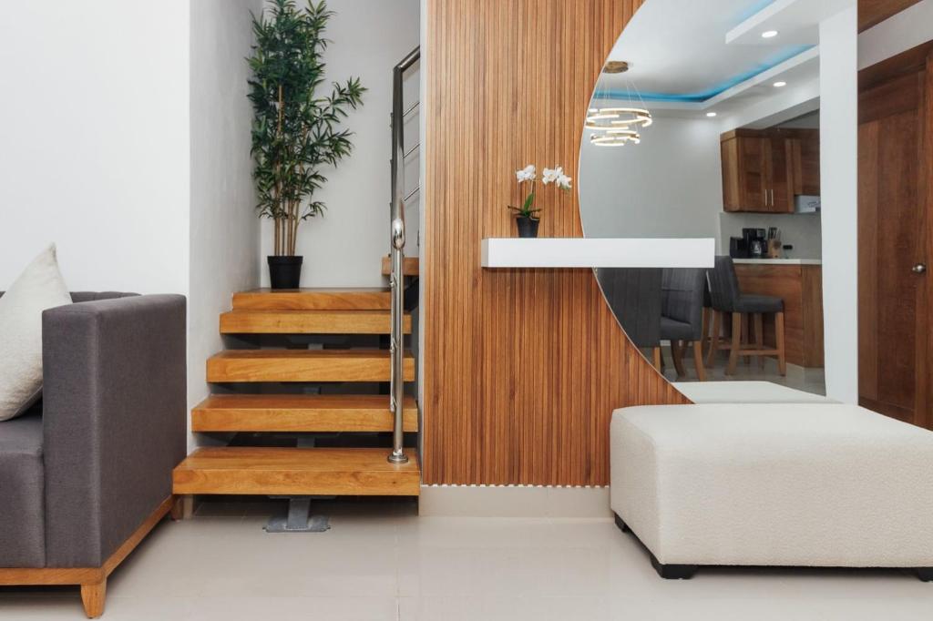 uma escada que leva a uma sala de estar com um espelho em Modern Luxury Apt w Outdoor Jacuzzi em Santiago de los Caballeros
