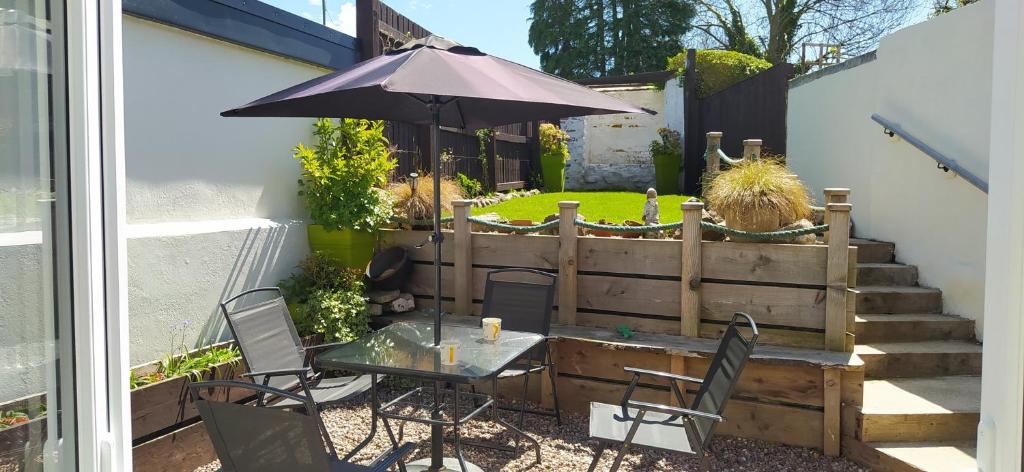 a patio with a table and an umbrella at Gorgeous dog friendly cottage in Kidwelly