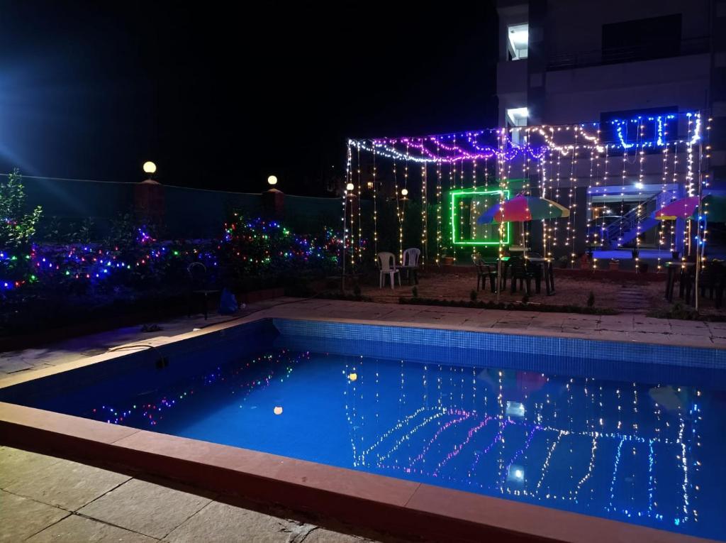 a house covered in christmas lights and a swimming pool at Hotel Oneness Palace in Mahabaleshwar