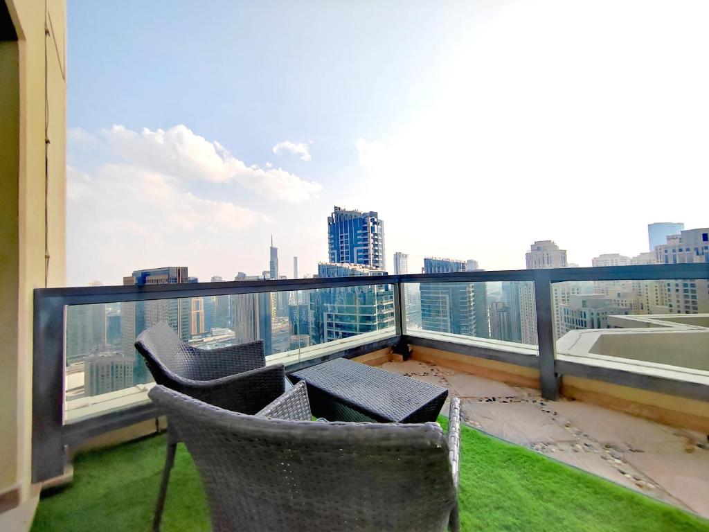 a balcony with two chairs and a view of a city at ELAN RIMAL SADAF Suites in Dubai