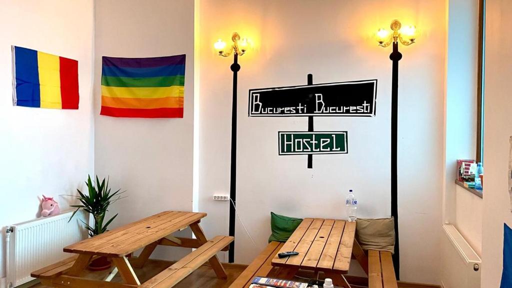 a room with a table and a sign on the wall at Bucuresti Bucuresti Hostel in Bucharest