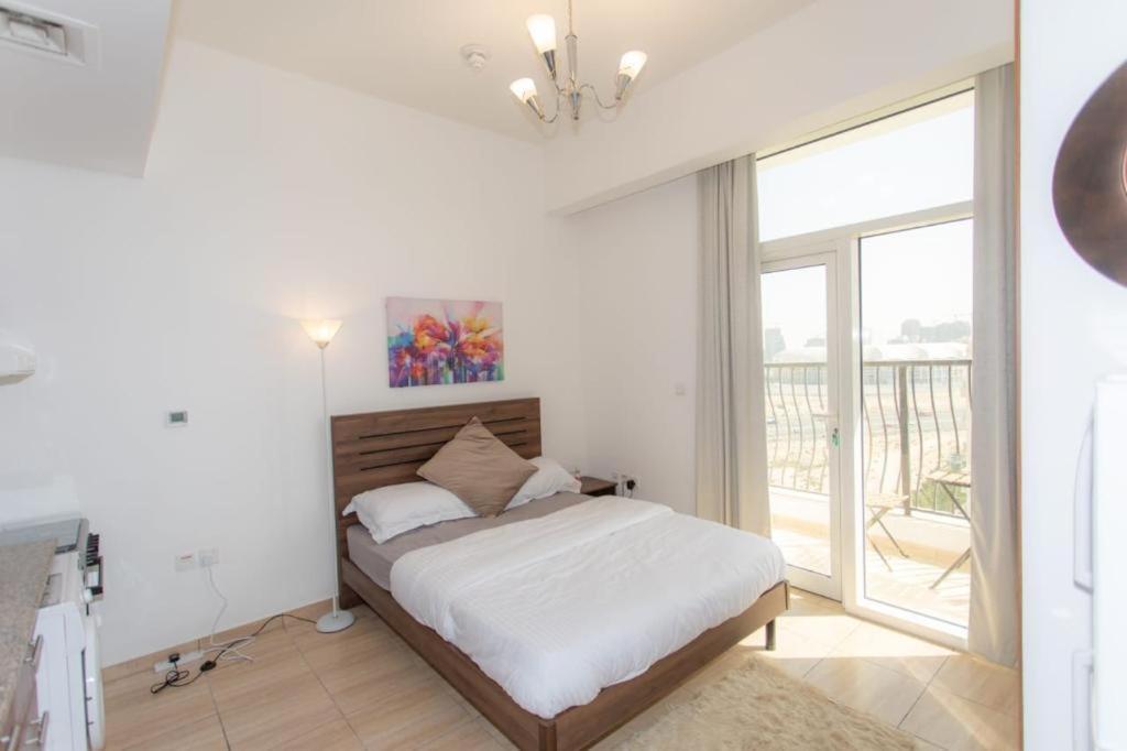 a bedroom with a bed and a large window at Fully Furnished Studio In JVC RL in Dubai