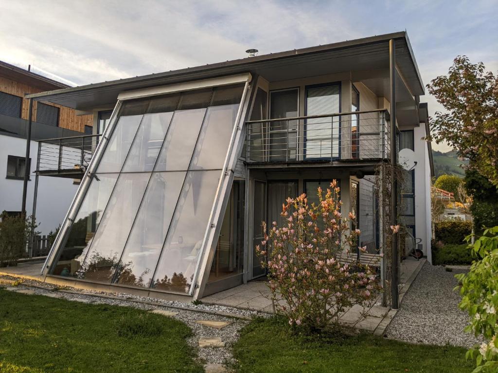 a house with large glass doors and a balcony at Ferienhaus in Westendorf in Westendorf