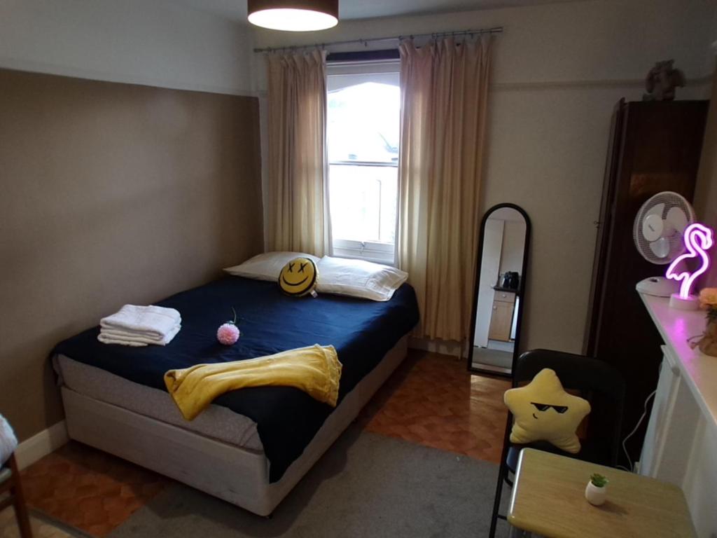 ein kleines Schlafzimmer mit einem Bett mit blauer Tagesdecke in der Unterkunft Top Chiswick Apartments, London Center Area in London