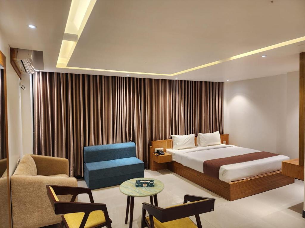 Pokój hotelowy z łóżkiem i krzesłem w obiekcie Sea Paradise w mieście Koks Badźar