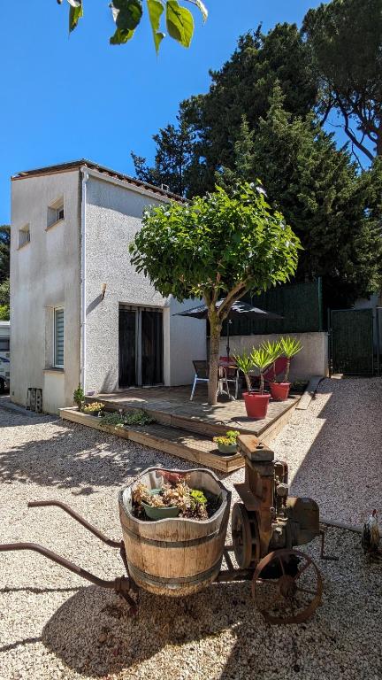 a old tractor sitting in a yard next to a building at Petite Maison indépendante. in Béziers