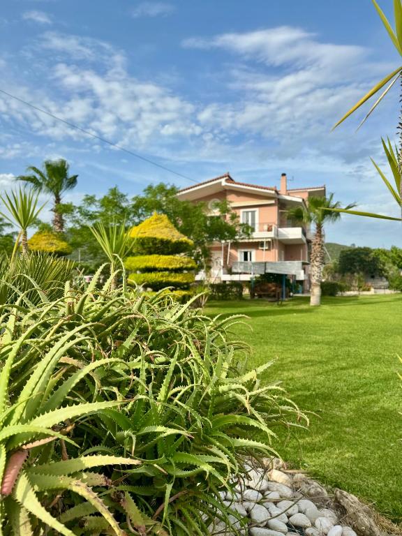 a house with a green yard with plants at Nonta's Garden - nature & waves in Yiannitsokhórion