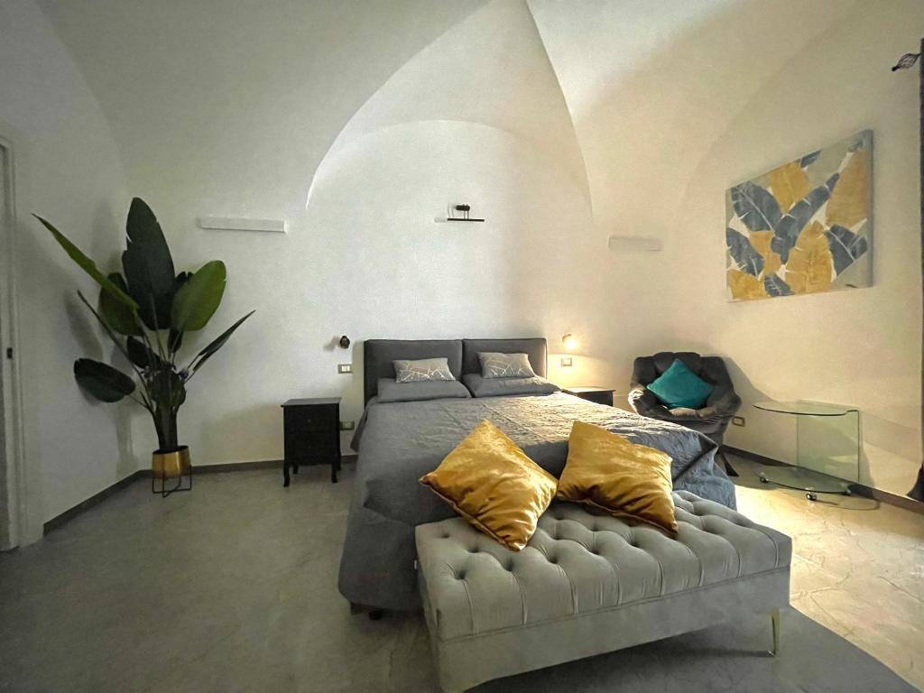 una camera da letto con un letto con cuscini gialli e un divano di Nel Cuore di Palermo Isidoro Palace a Palermo